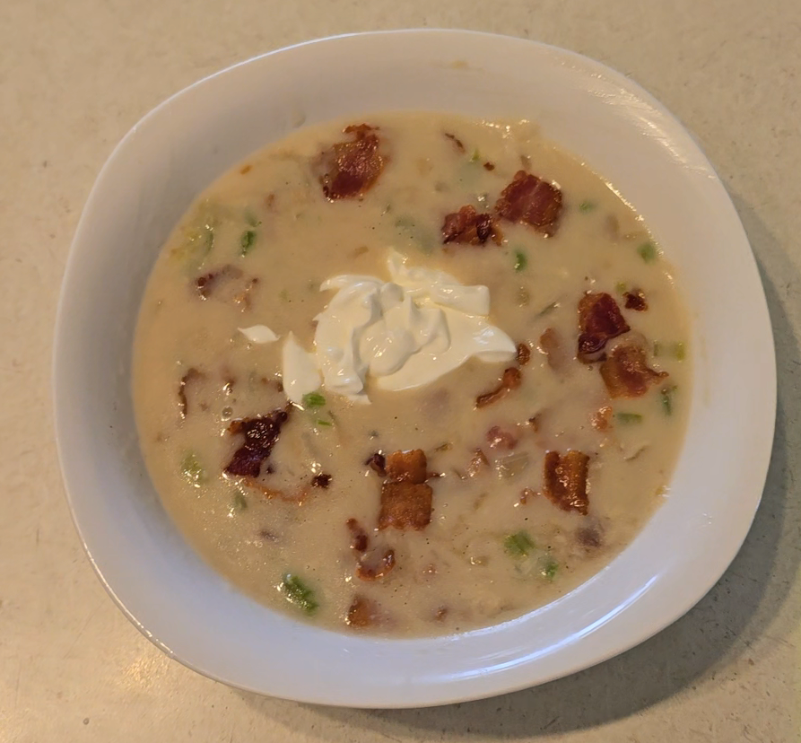 image of a bowl of sherry calm chowder with bacon bits and a dollop of sour cream