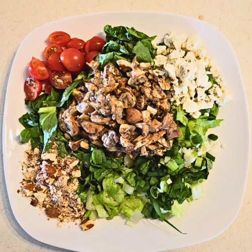 Lettuce greens, cherry tomatoes, blue cheese crumbles, green onions and walnuts (in this case almonds) come together with marinated mushrooms in this divine salad.